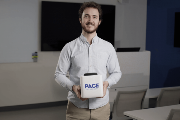 Bradford Terry from Pace University holding a Catchbox Cube with a custom cover featuring the Pace logo.