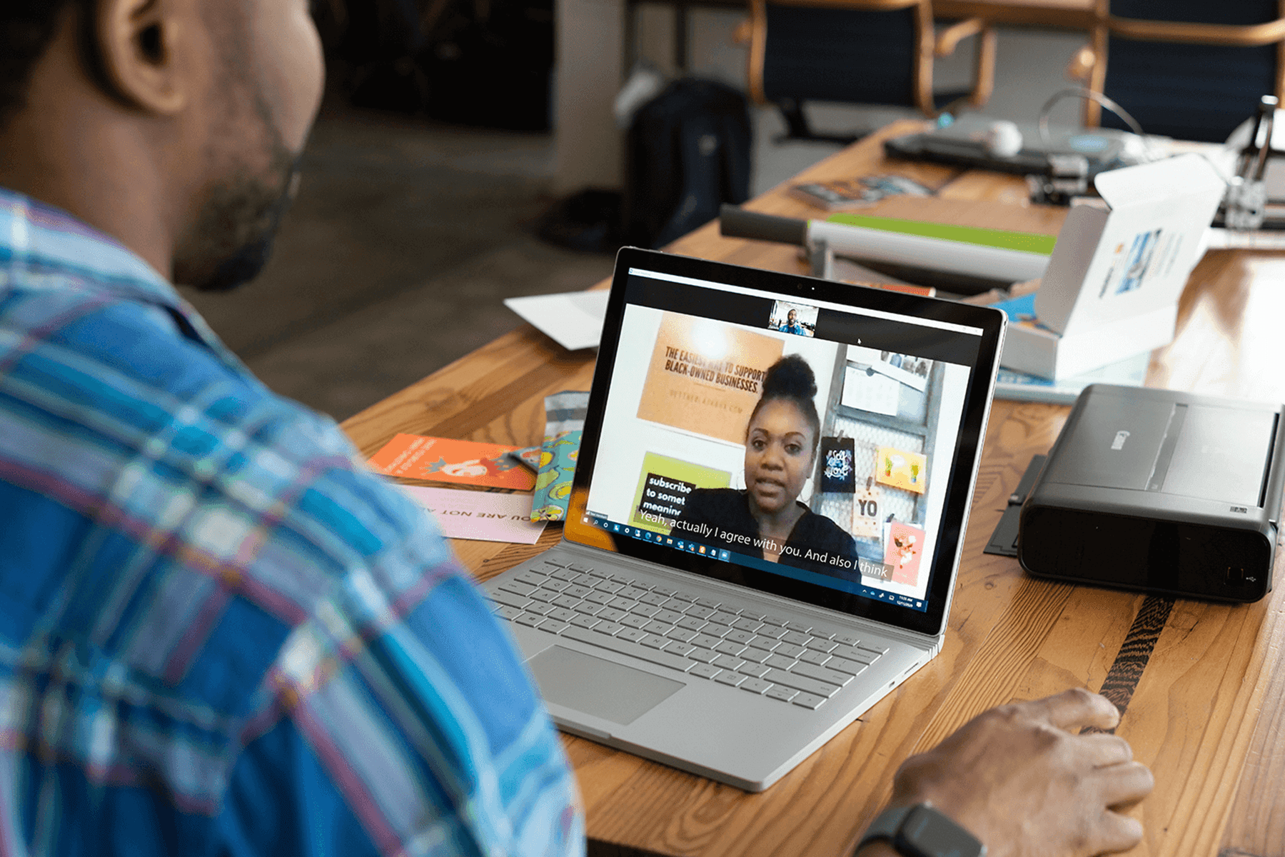 Person participating in a virtual meeting on a laptop, with live captions displayed on the screen.