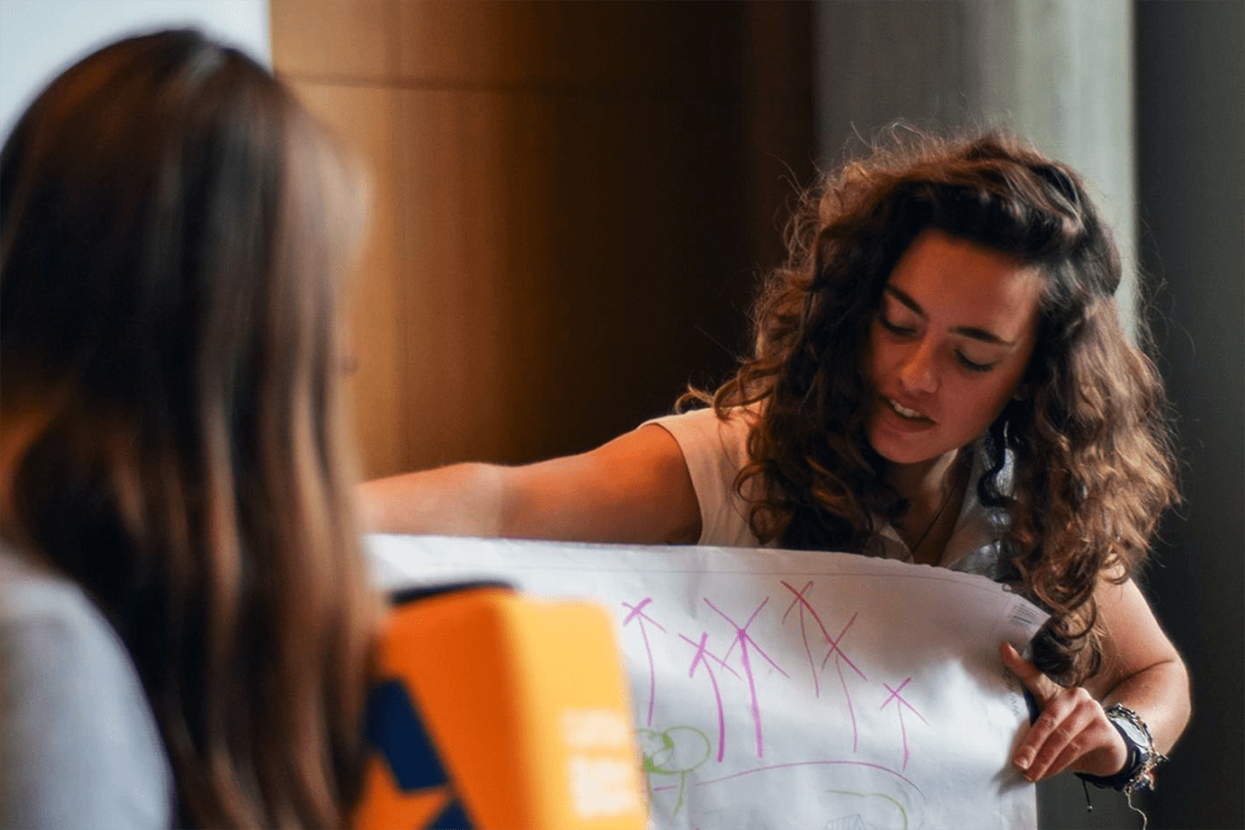 Students presenting a group project with a poster, using a Catchbox Cube to amplify their voices.