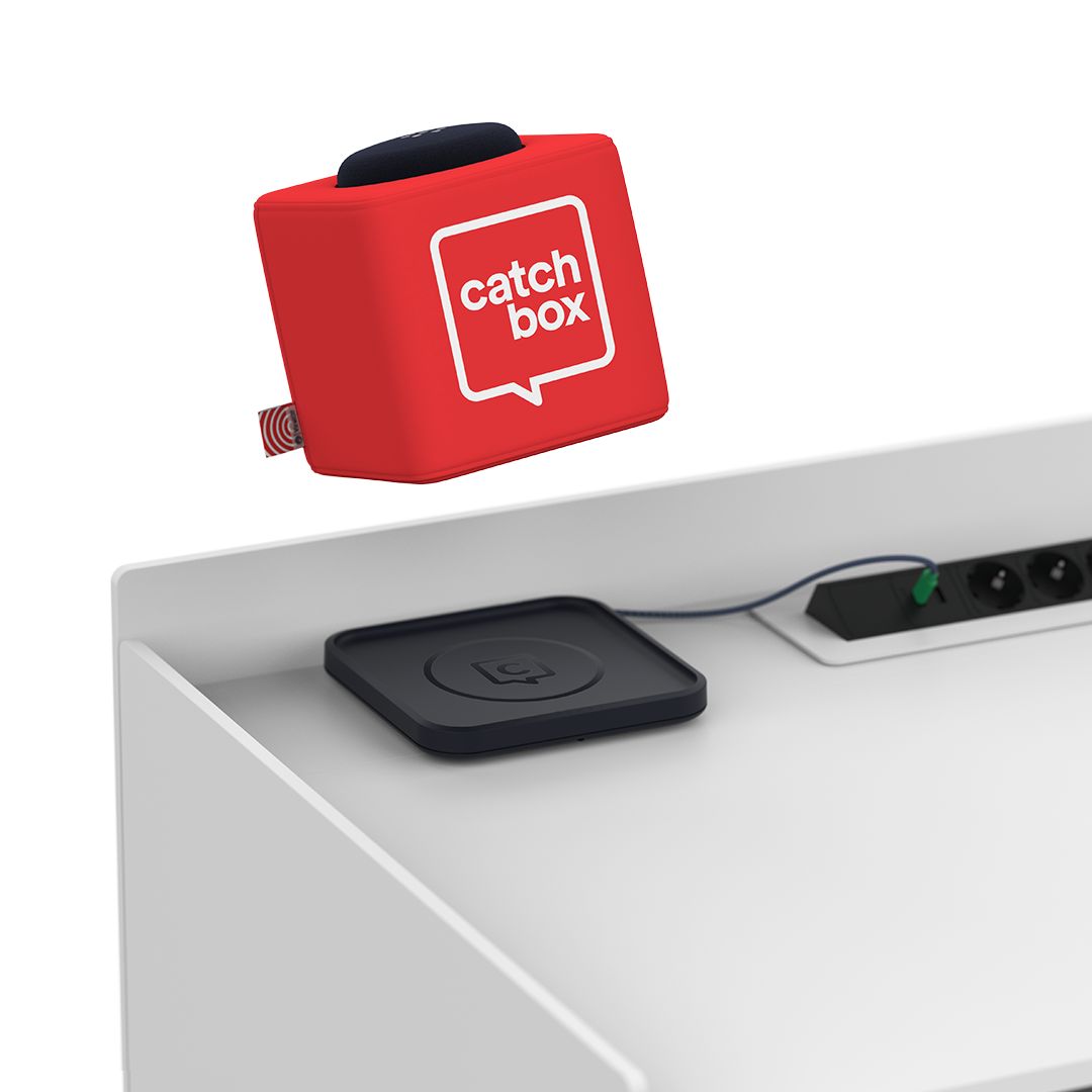 Catchbox Cube microphone being picked up from its Charging Base, which is placed on a lectern .