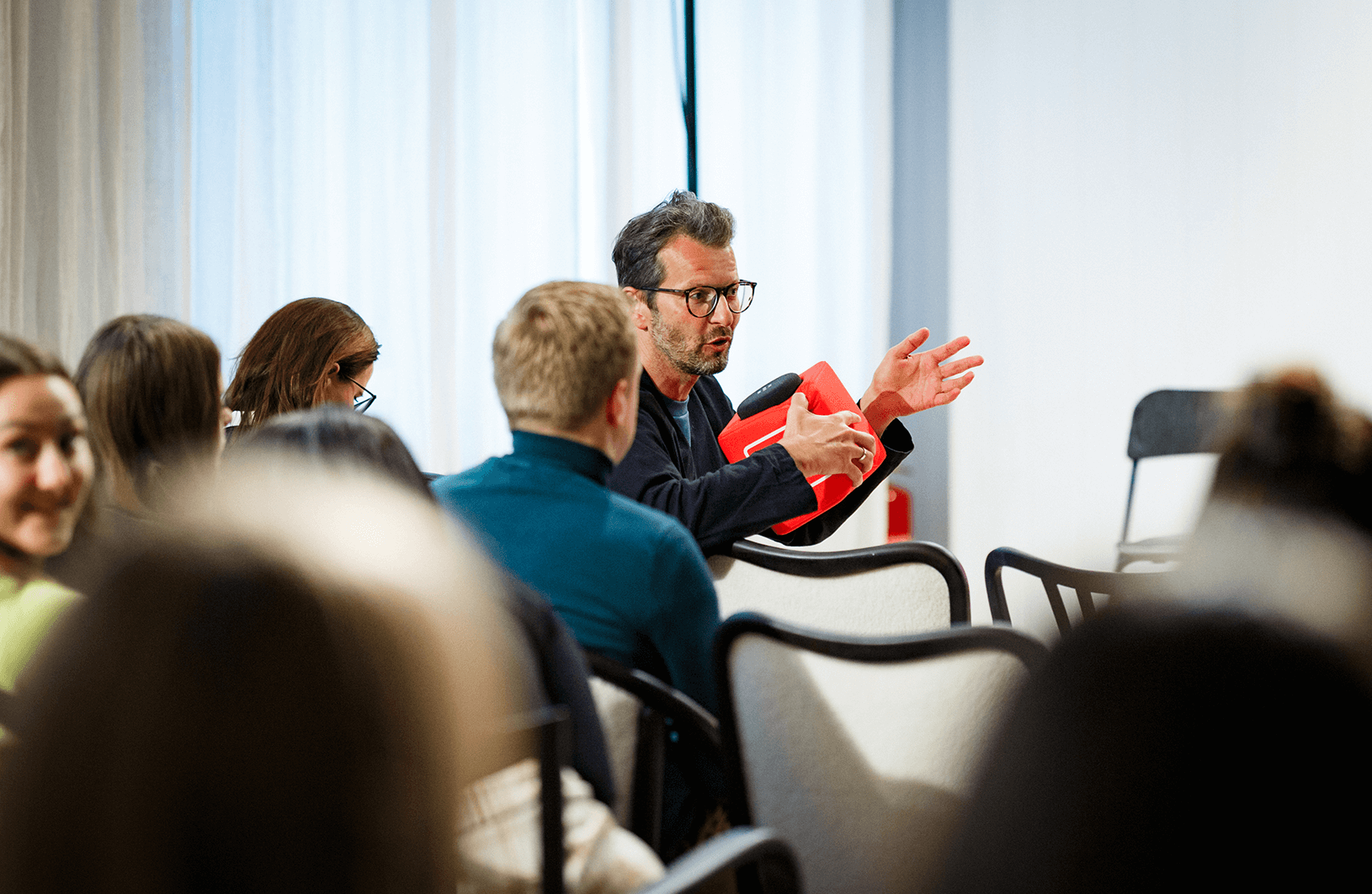 Person in audience using Catchbox Cube for crystal clear audio capture in conference room