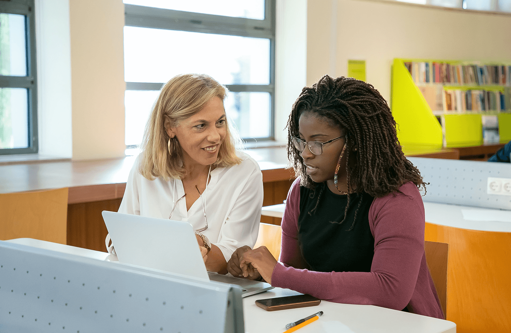Student and tutor sitting in front of a computer, actively participating in a virtual lecture. The inclusive use of technology enhances accessibility in higher education.